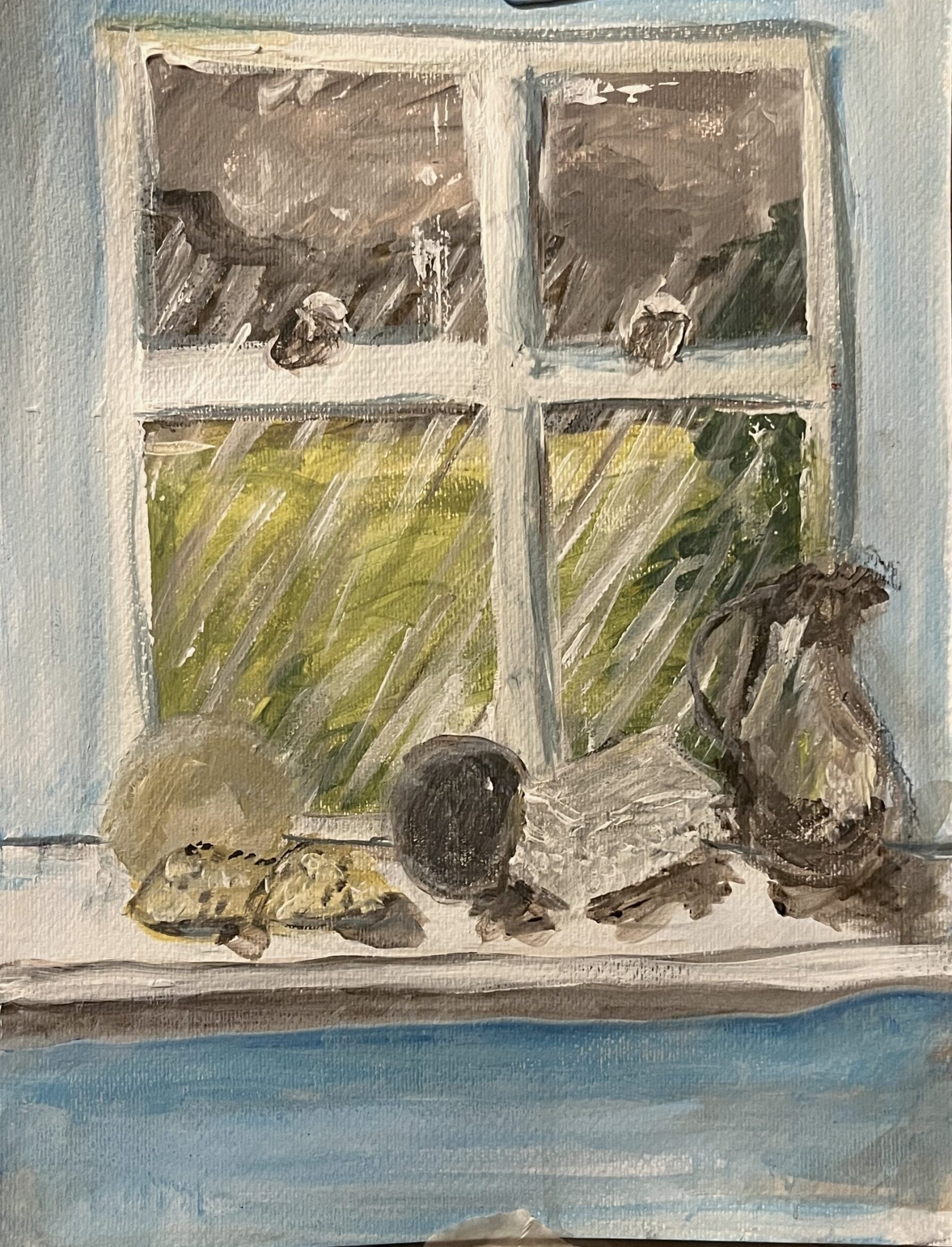 Still life on a windowsill with objects and a rain-streaked window looking out onto green landscape.